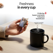Hand holding a coffee bag above a steaming black mug with text about coffee freshness.