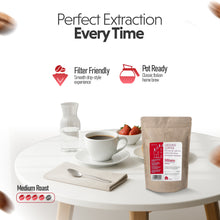 Ground coffee package with a cup of coffee on a table, featuring text about coffee quality.