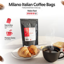 Milano Italian Coffee Bags with a cup of coffee and pastries on a table.
