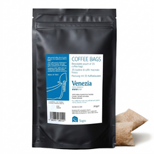 Black coffee bag packaging with 'Venezia' label and coffee bags on a white background